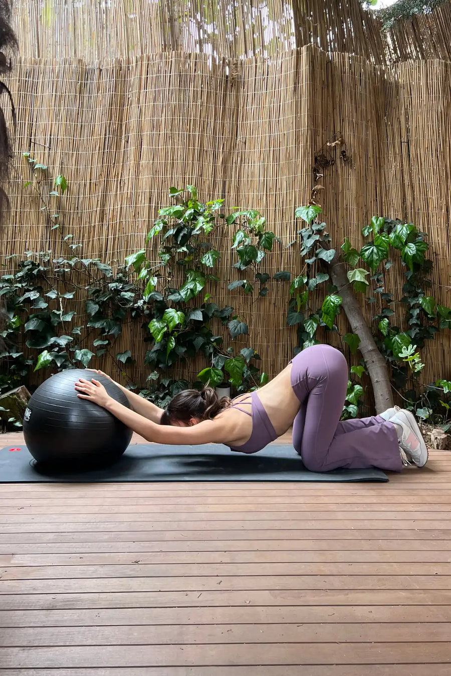 Spor topu ile esneyen kadın.